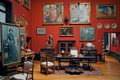 a living room filled with lots of paintings and furniture