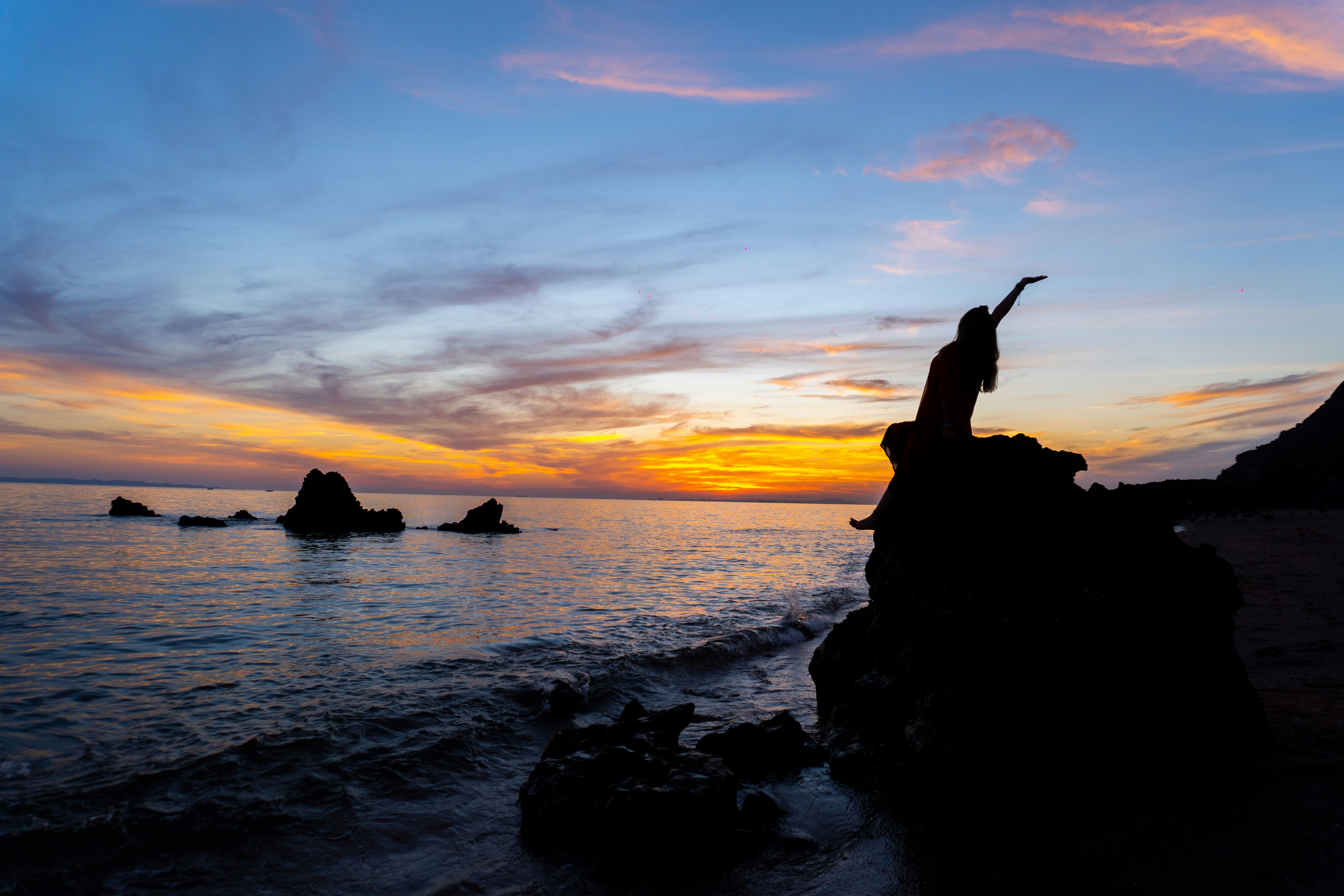 A person standing on a rock near the ocean photo – Free Nature Image on ...