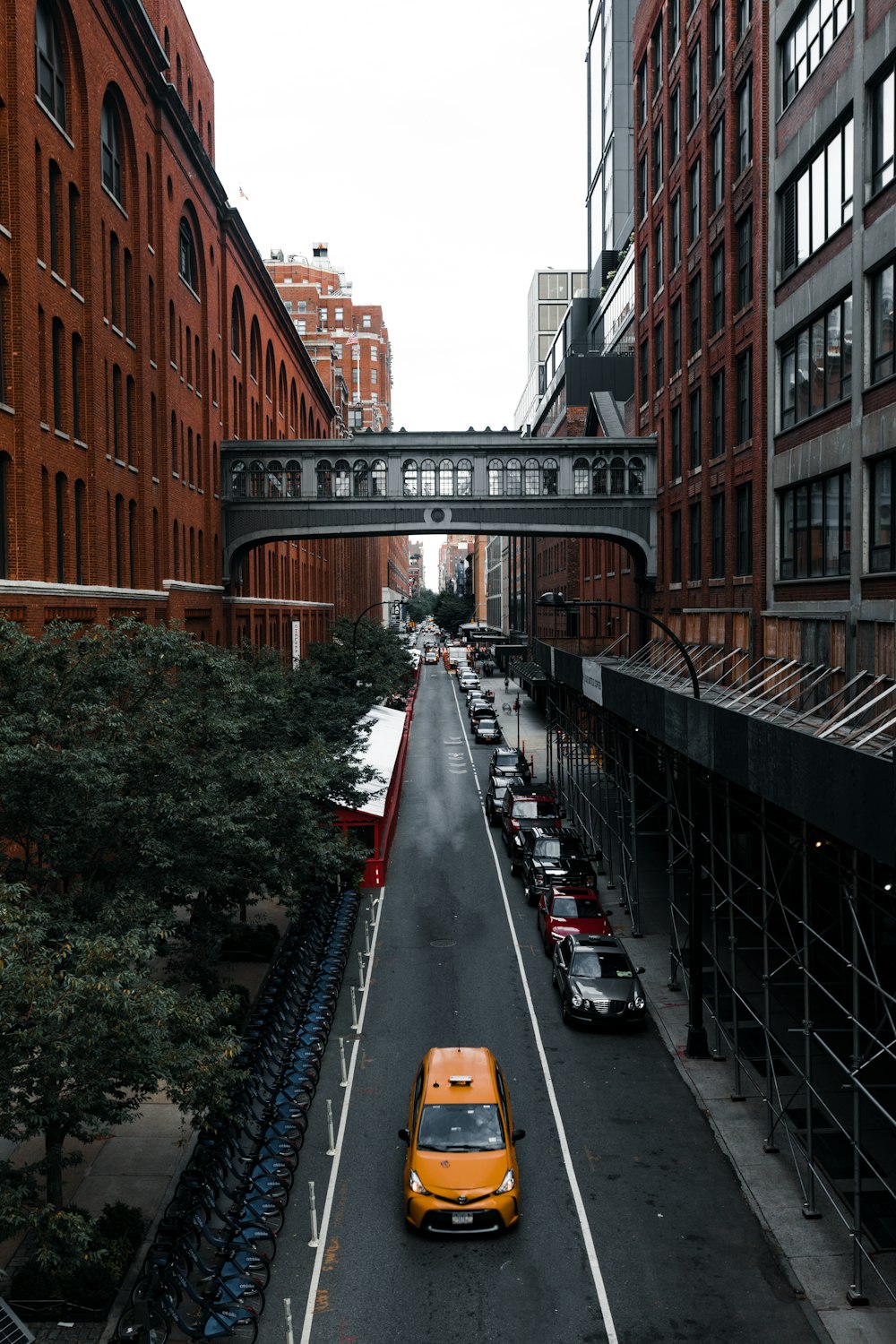 a yellow taxi cab driving down a street next to tall buildings