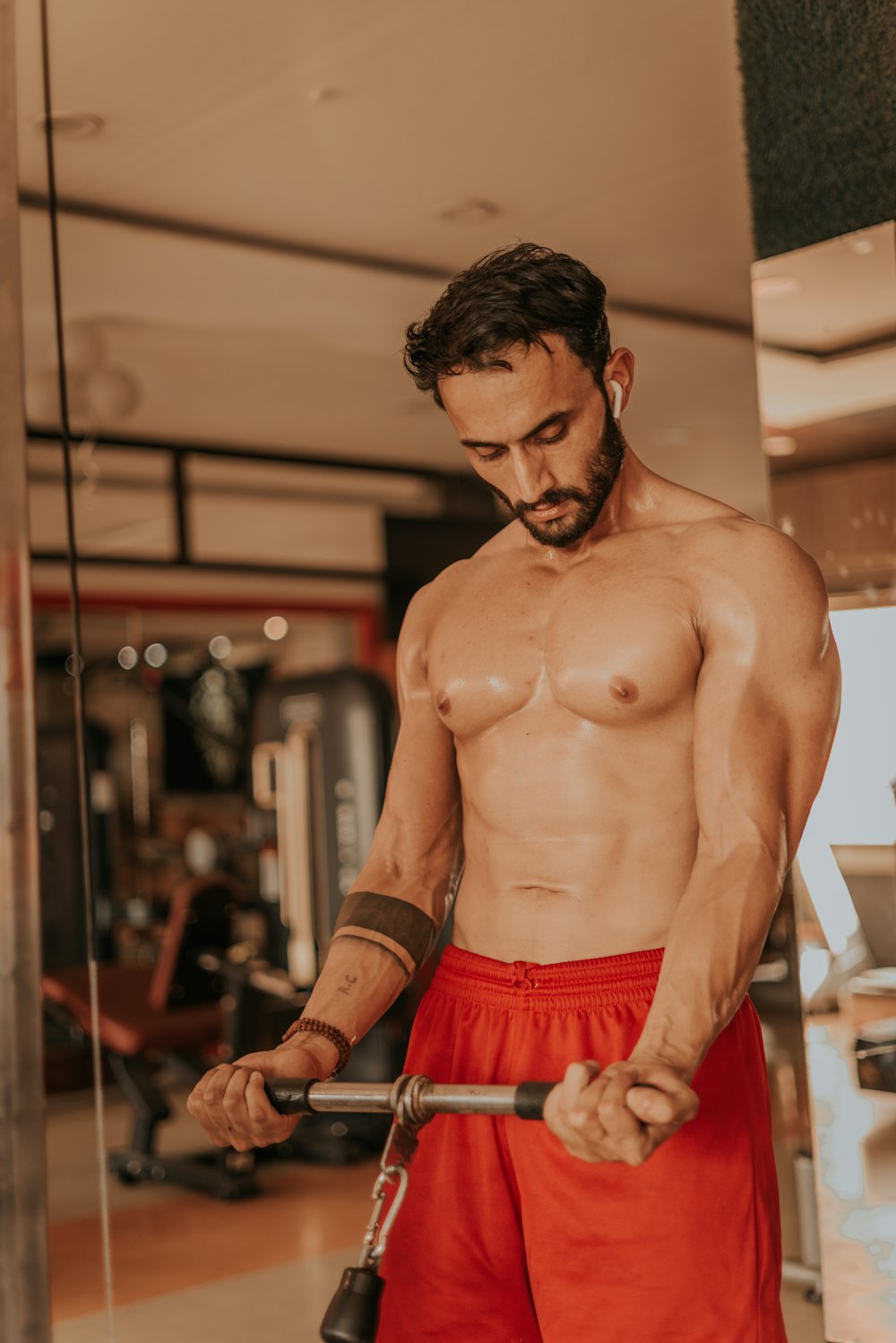 a shirtless man holding a barbell in a gym