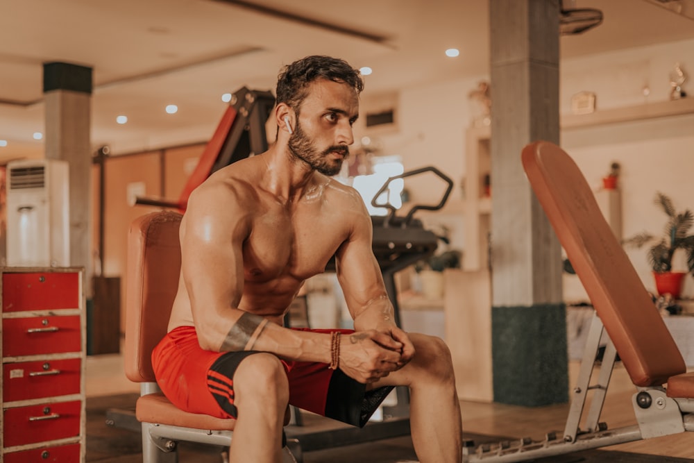 a man sitting on a bench in a gym