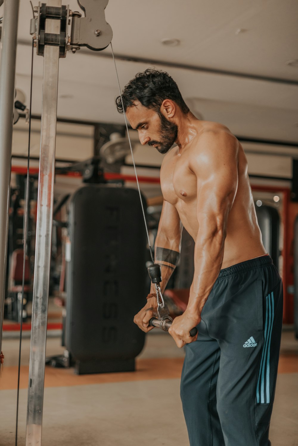 a shirtless man holding a rope in a gym