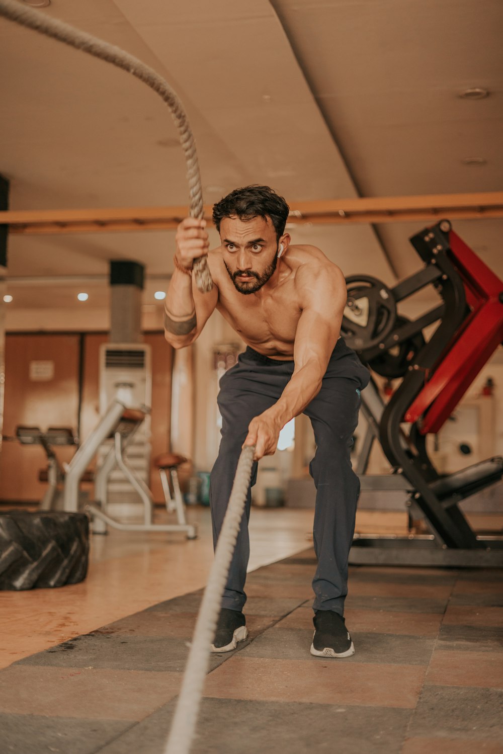 Un hombre está haciendo ejercicios con una cuerda en un gimnasio