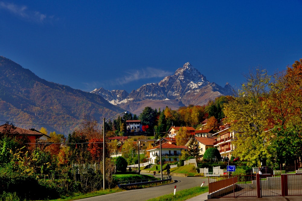 a scenic view of a town with mountains in the background