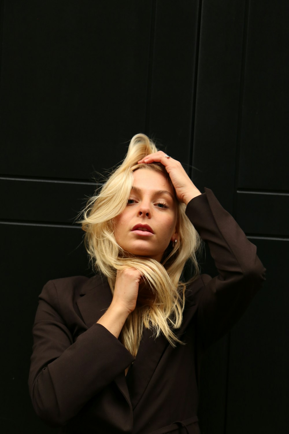 a blonde woman with her hand on her head