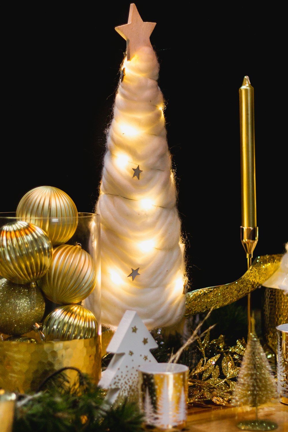 a white christmas tree surrounded by gold and silver ornaments