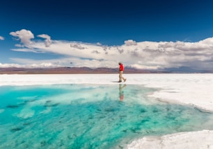 a man standing on the edge of a body of water