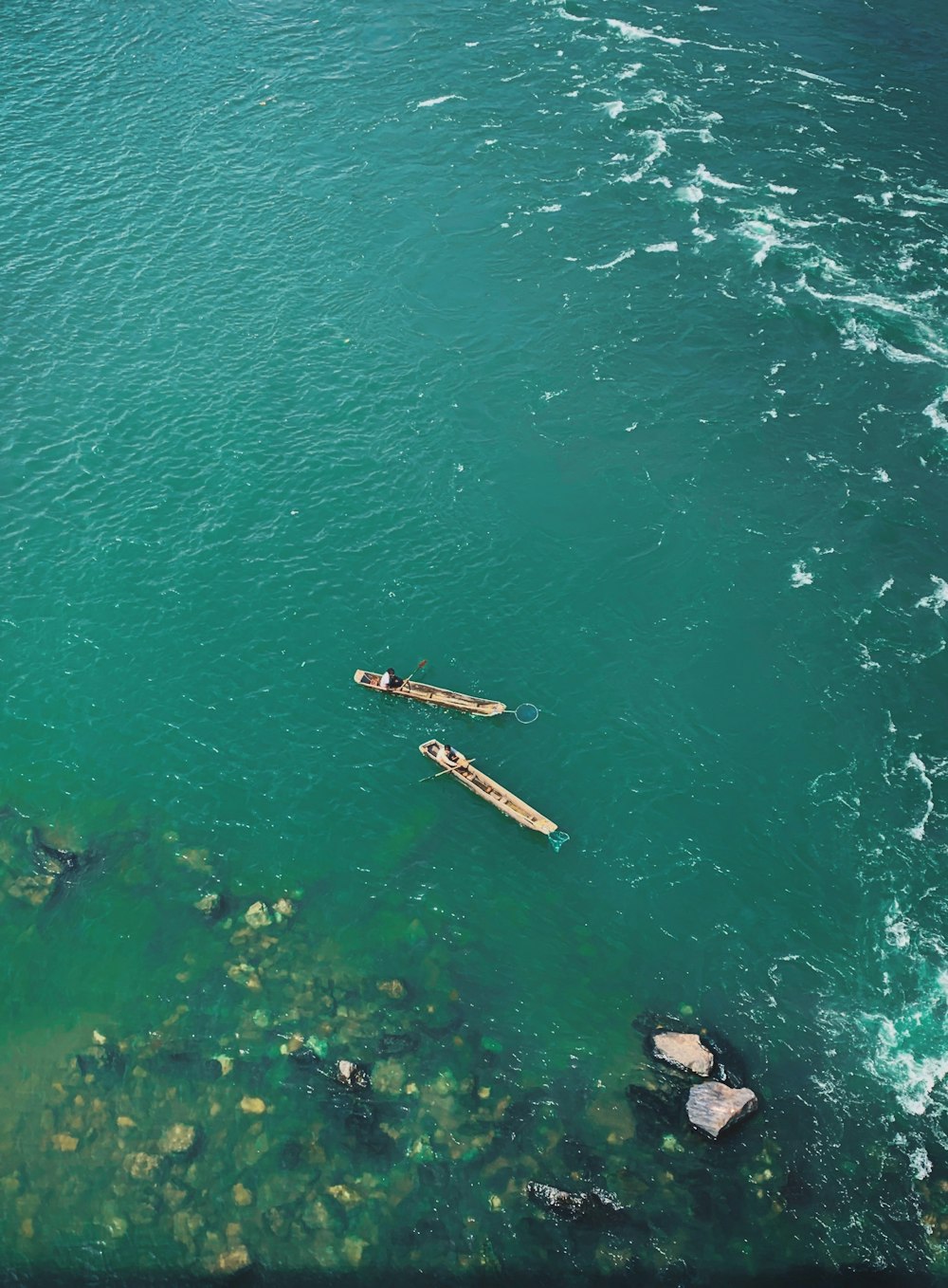 a couple of boats floating on top of a body of water