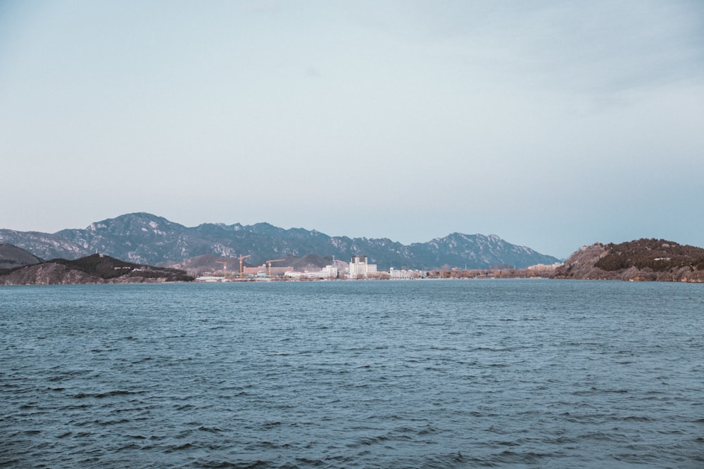 a body of water with mountains in the background