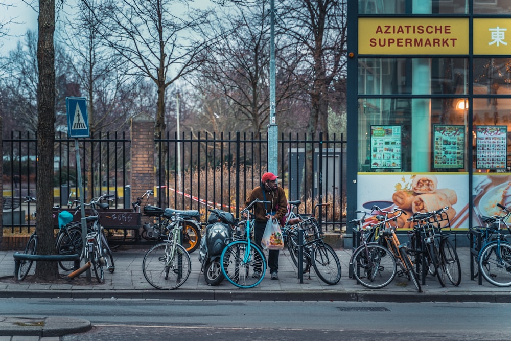 a man standing next to a row of parked bikes