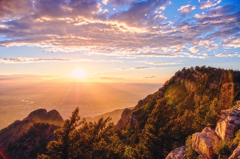 the sun is setting over a mountain range