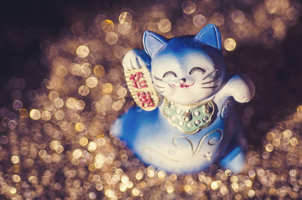 a blue cat figurine sitting on top of a table