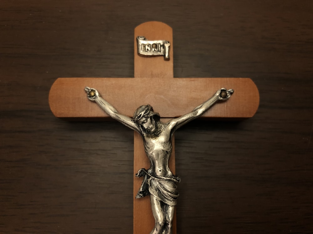 un crucifijo en una pared de madera con una cruz en él
