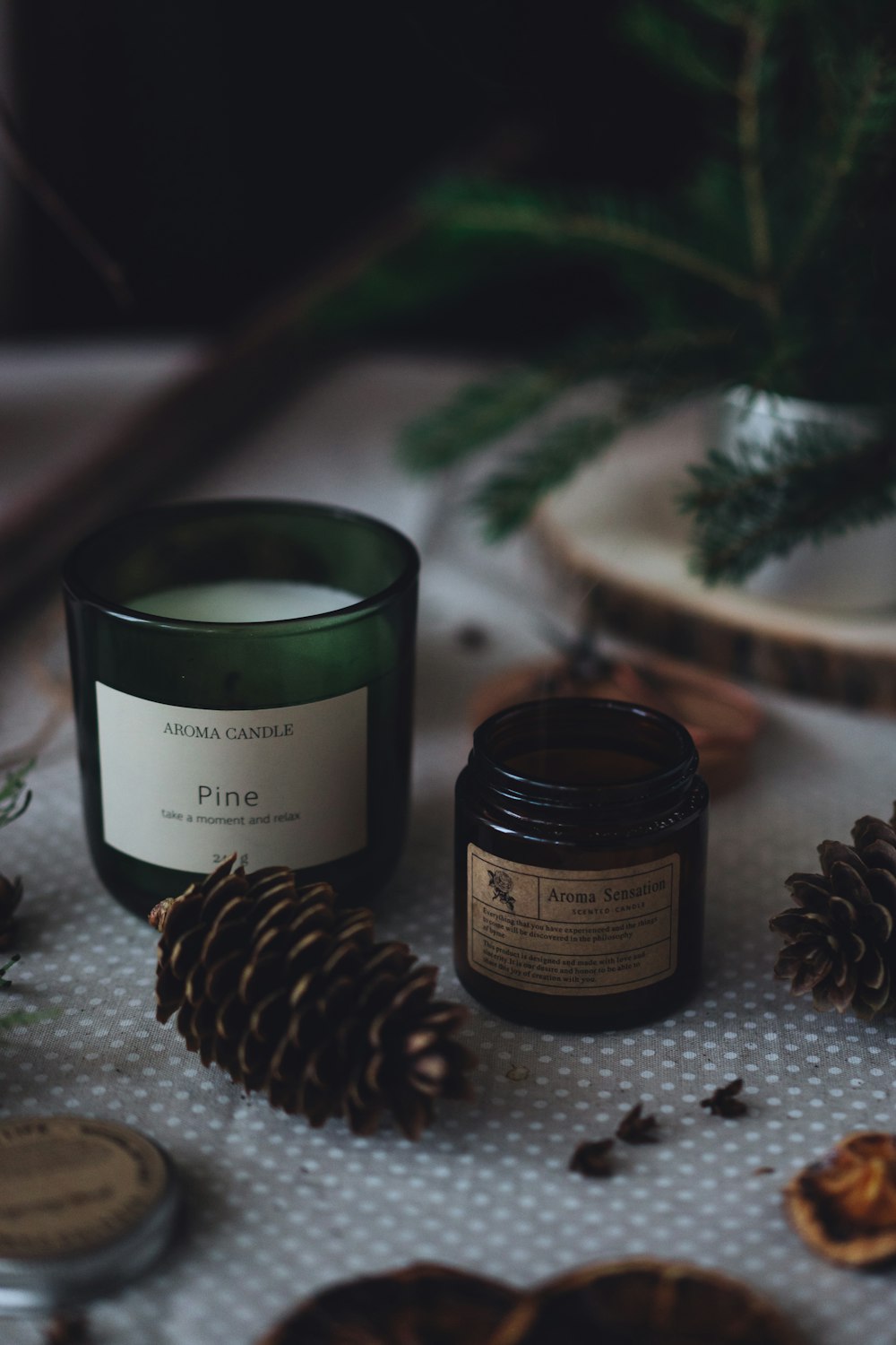 a candle and some pine cones on a table