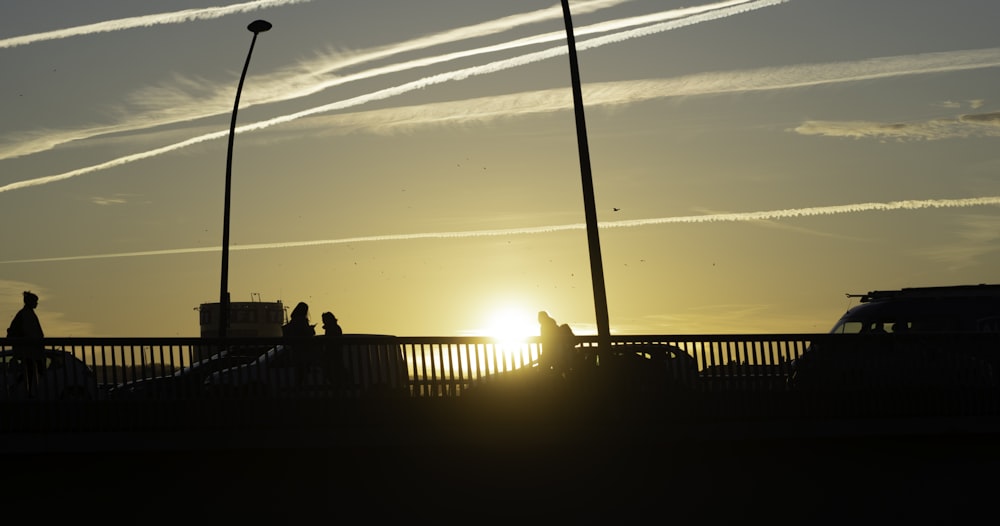 Un grupo de personas caminando por un puente al atardecer