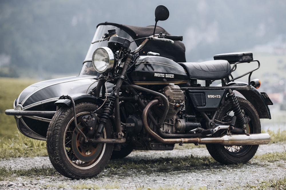 a black motorcycle parked on a gravel road