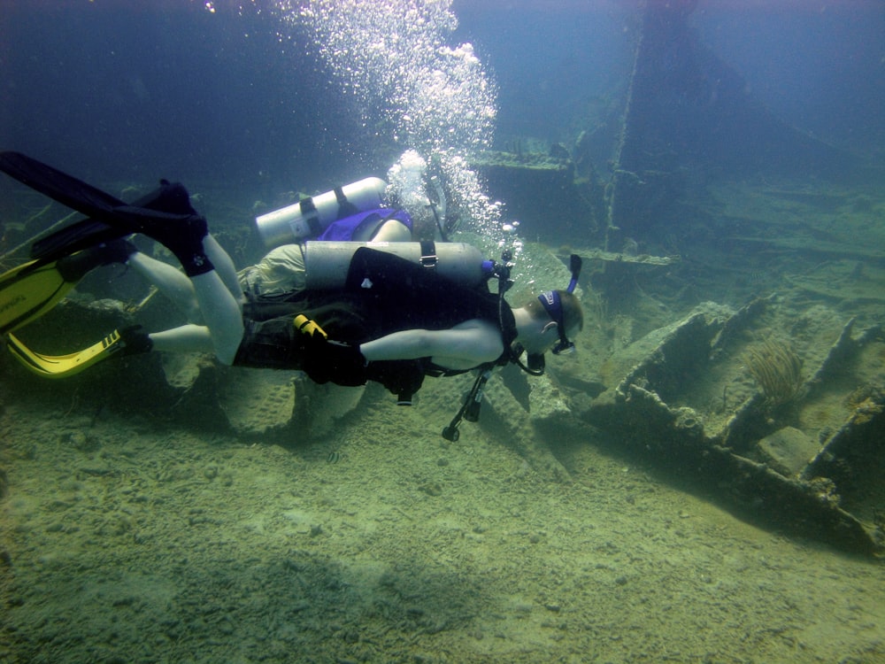 a man in a scuba suit is swimming in the water