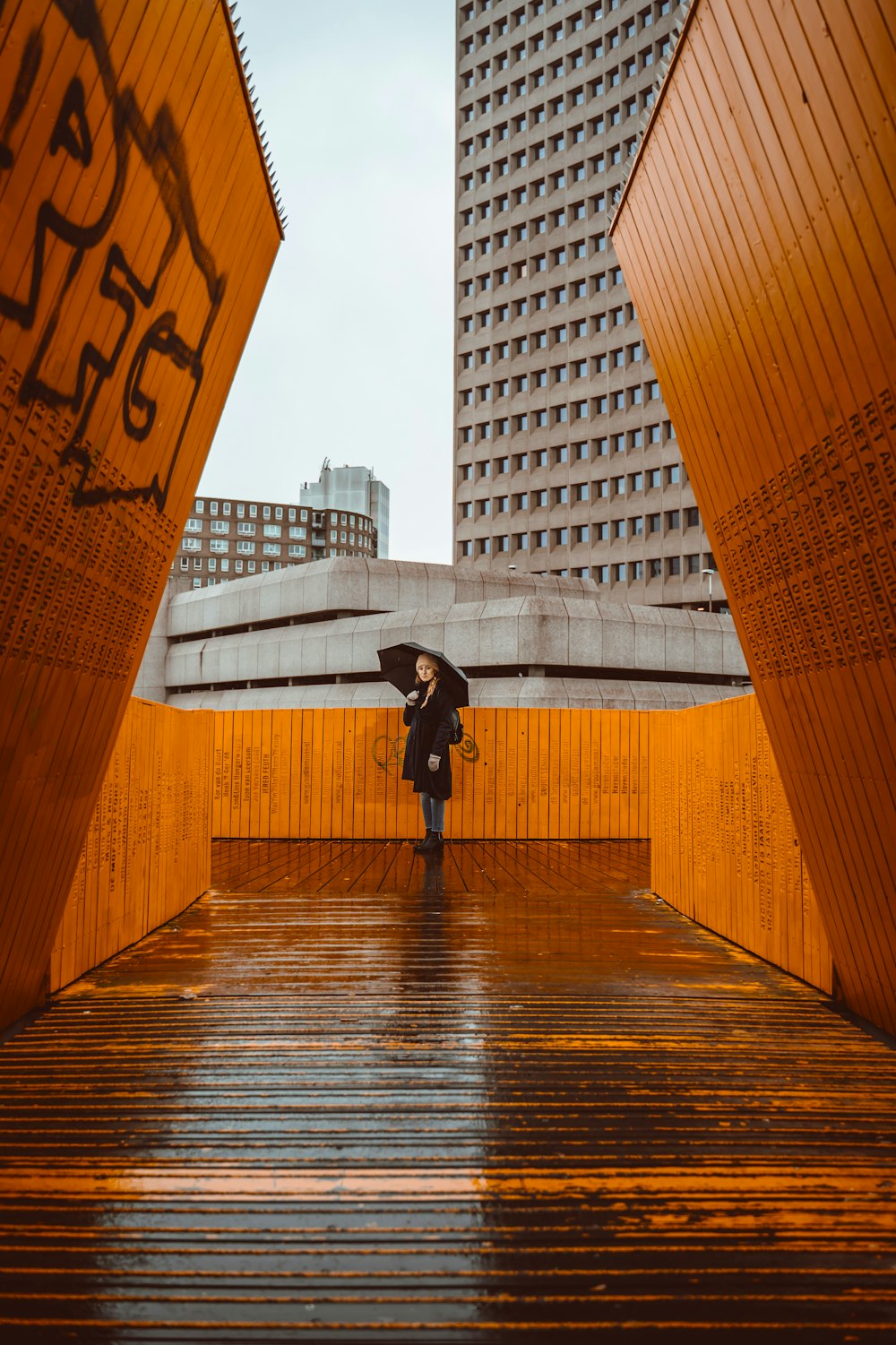 雨の中に立つ傘を持つ女性