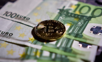 a bitcoin sitting on top of a pile of money
