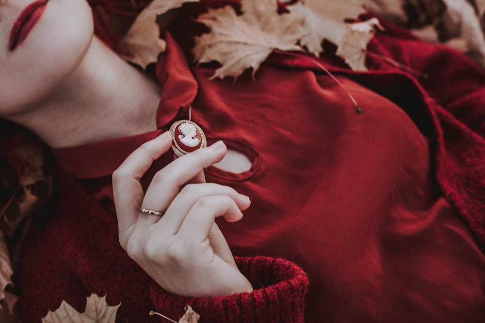 a woman in a red dress is holding a ring