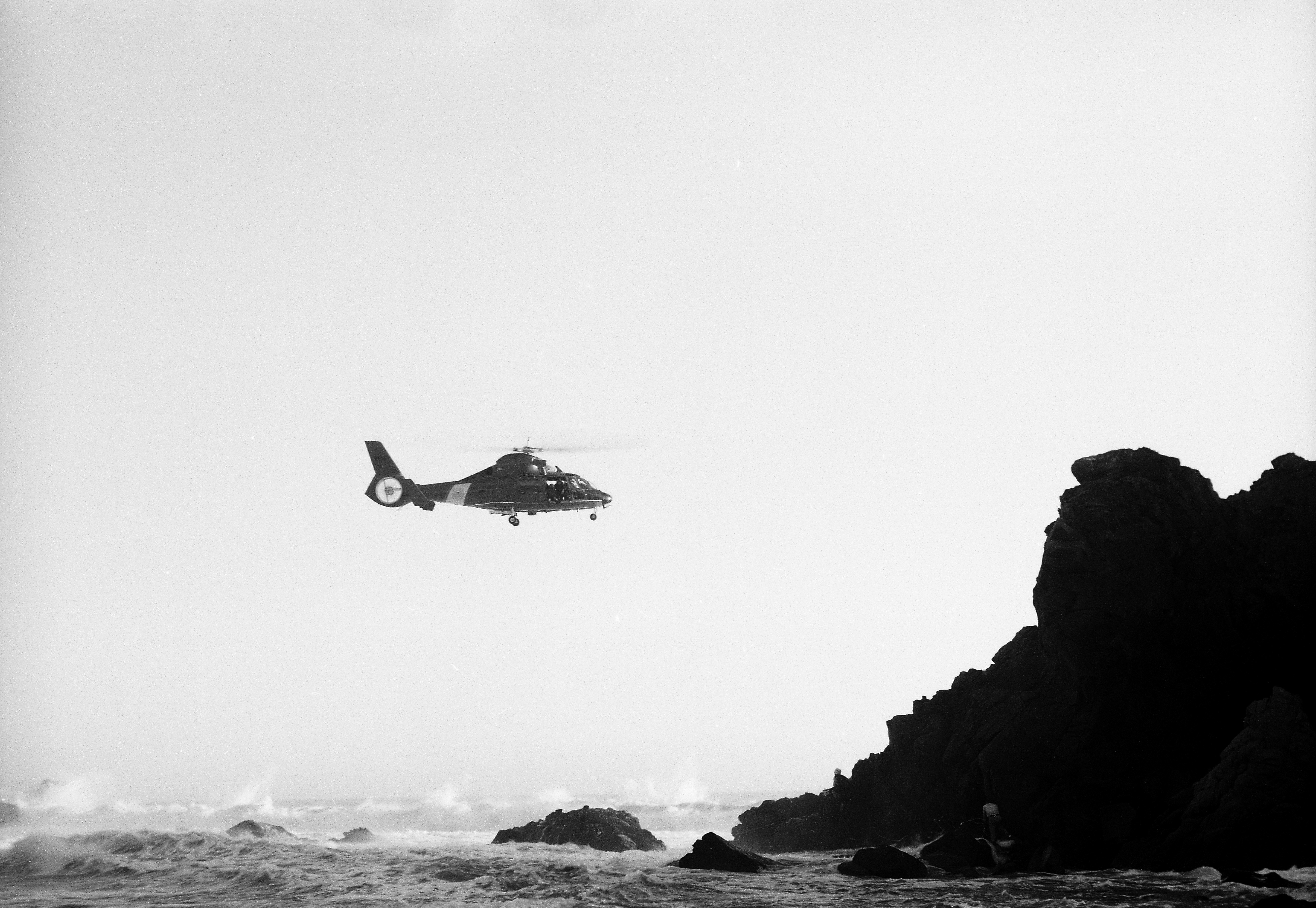 foto hitam putih helikopter yang terbang di atas lautan