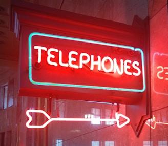 a neon sign that says telephones on it