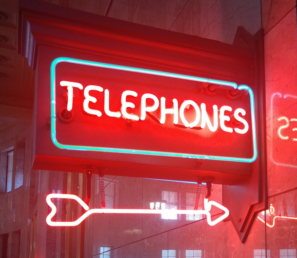 a neon sign that says telephones on it