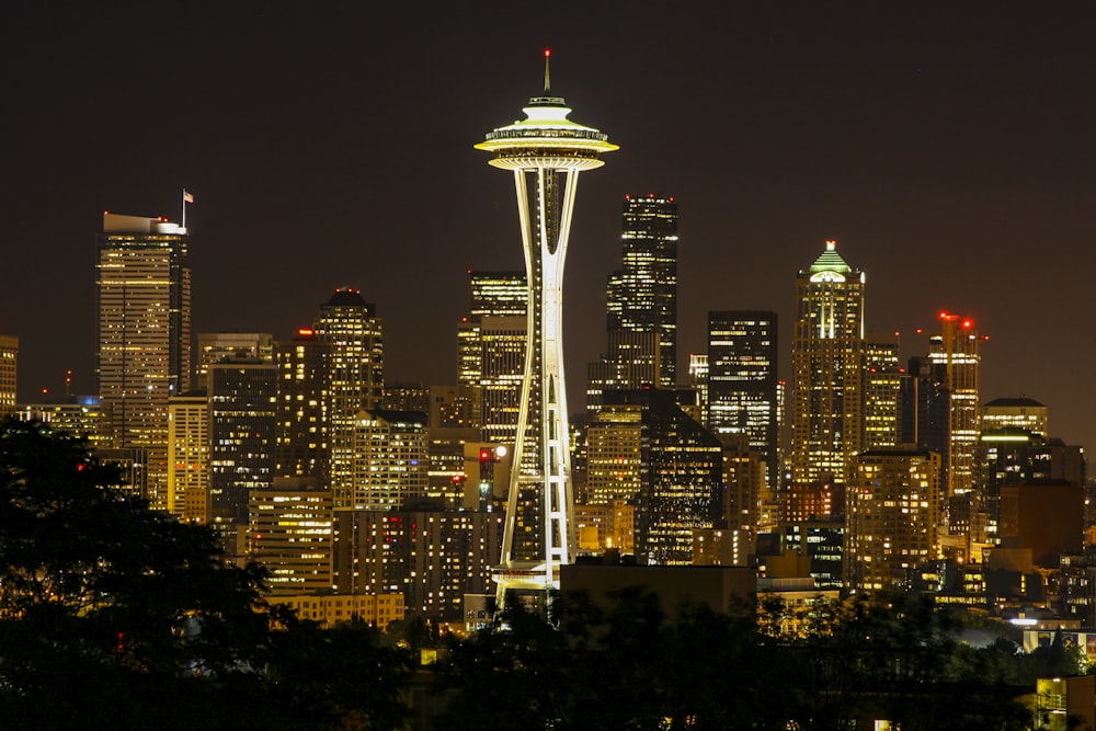 a view of a city at night with the space needle in the foreground