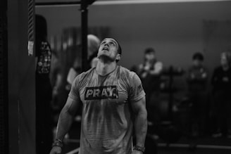 a man standing in a gym holding a barbell