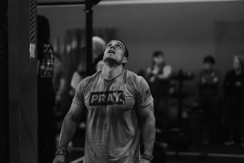 a man standing in a gym holding a barbell