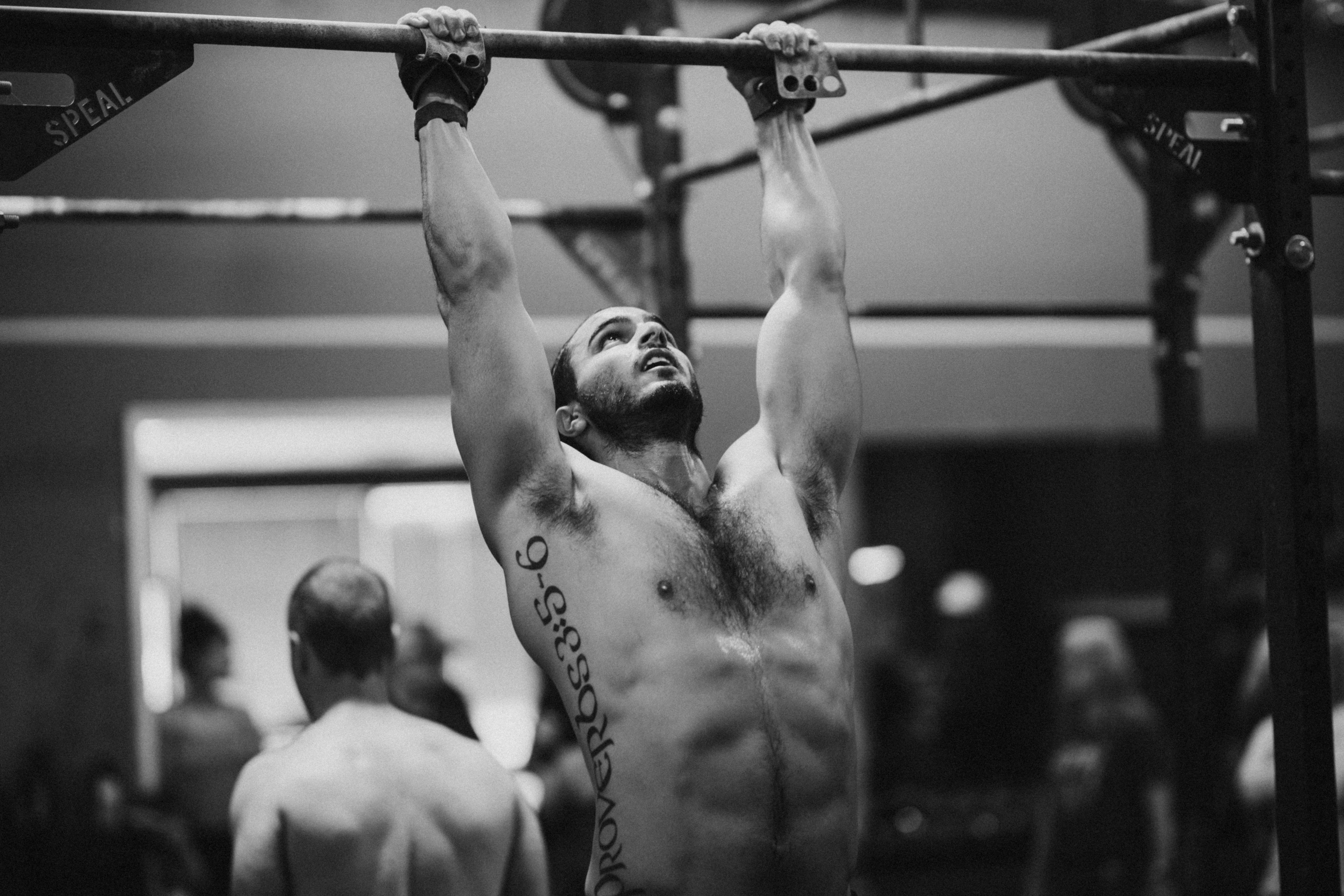a man doing a pull up on a bar in a gym