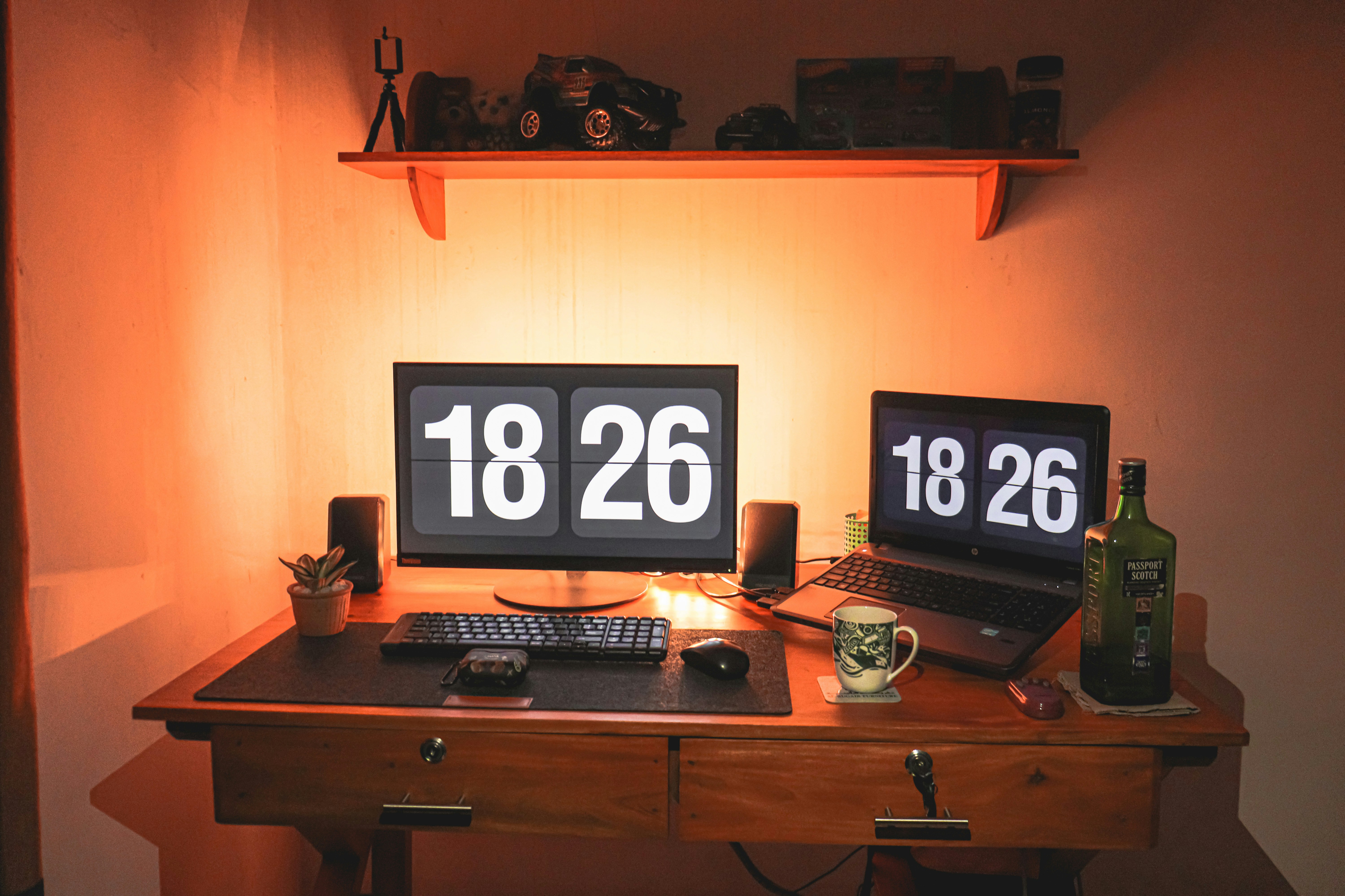 a desk with a computer and a clock on it