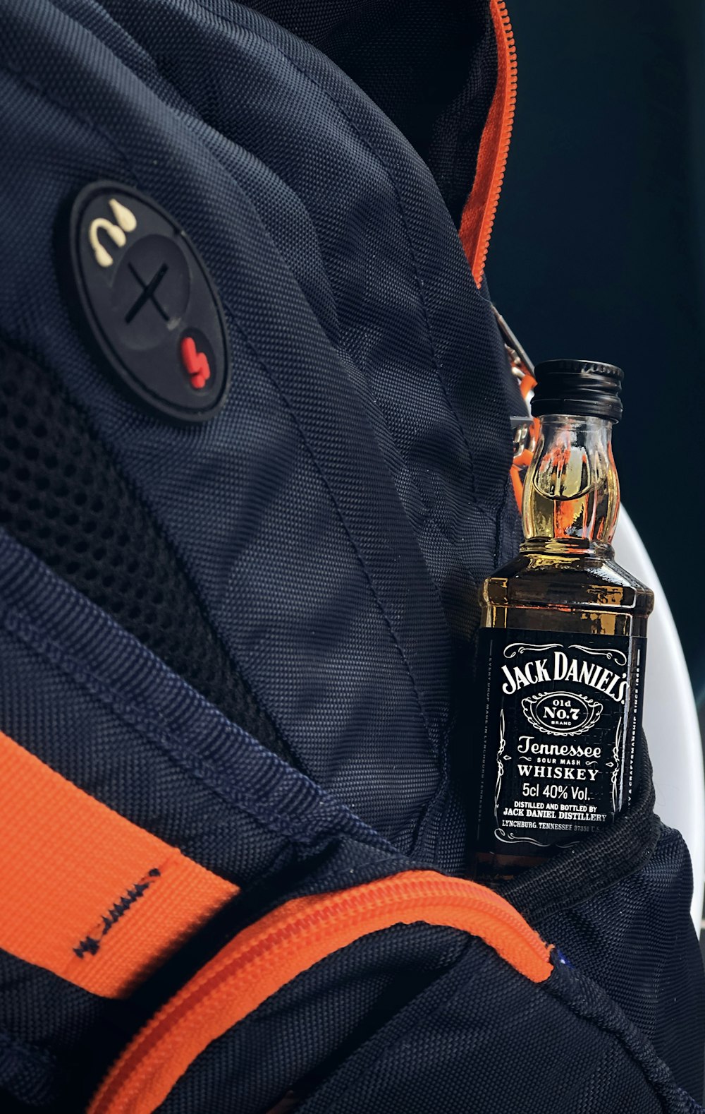 a bottle of jack daniels sitting on top of a backpack