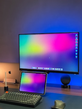 a computer monitor sitting on top of a desk next to a keyboard