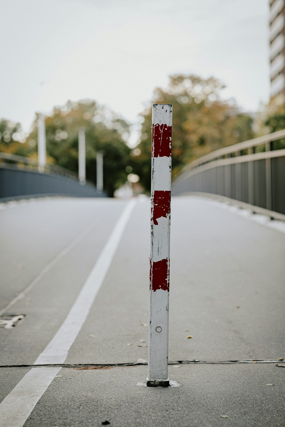 Un poste rojo y blanco sentado al costado de una carretera