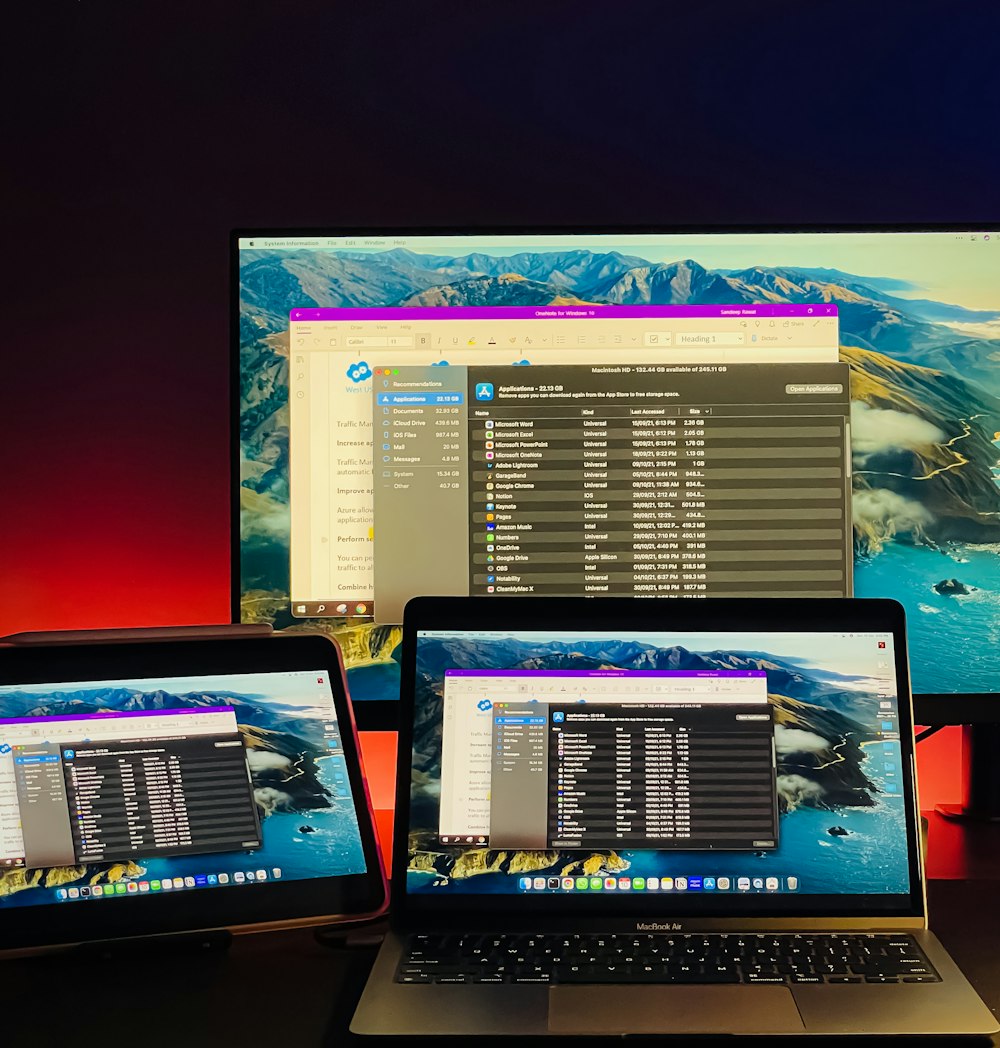 a couple of laptop computers sitting on top of a desk