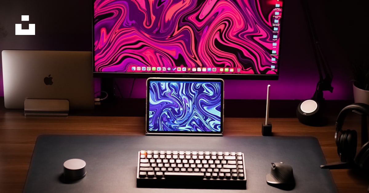 A desk with a laptop, keyboard and monitor photo – Free Computer Image ...