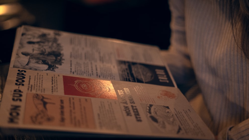 uma pessoa está lendo um jornal com uma luz brilhando sobre ele
