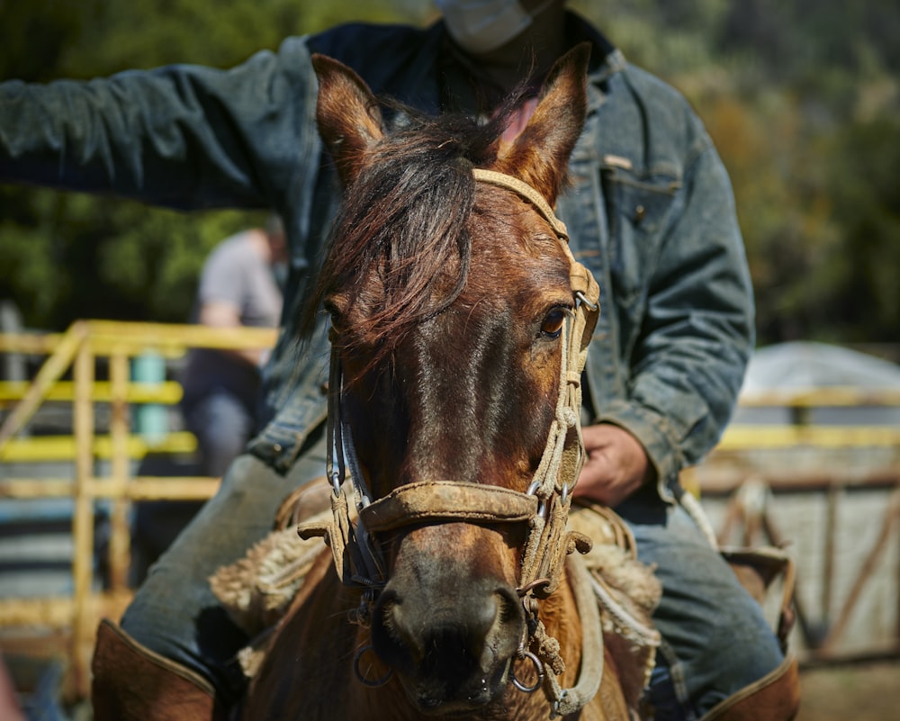 Un hombre con una máscara facial montando a caballo