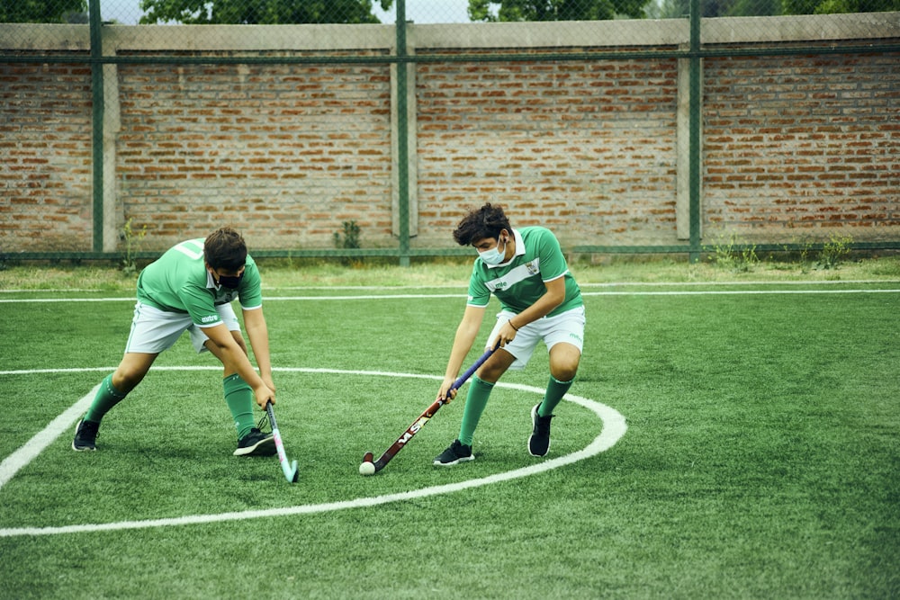 two young men playing a game of field hockey