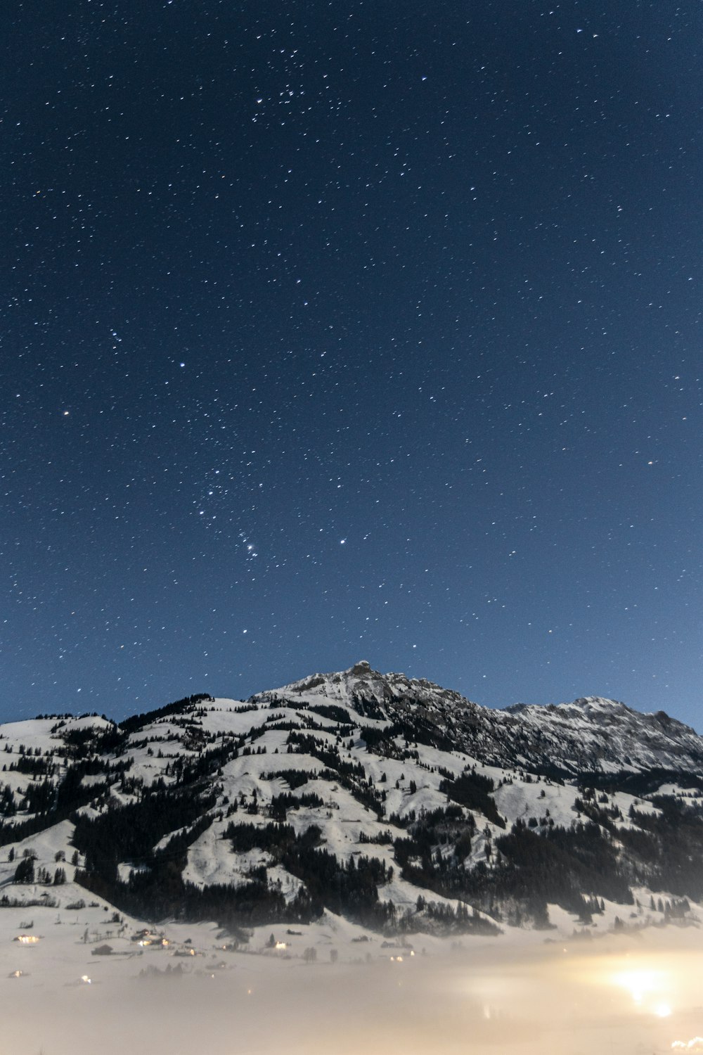 a mountain covered in snow under a night sky