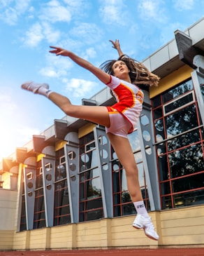 a woman in a red and white uniform jumping in the air