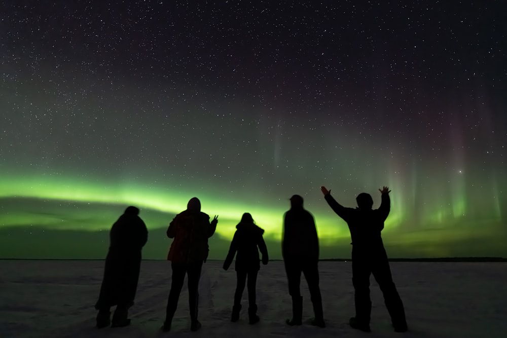 a group of people standing on top of a snow covered ground