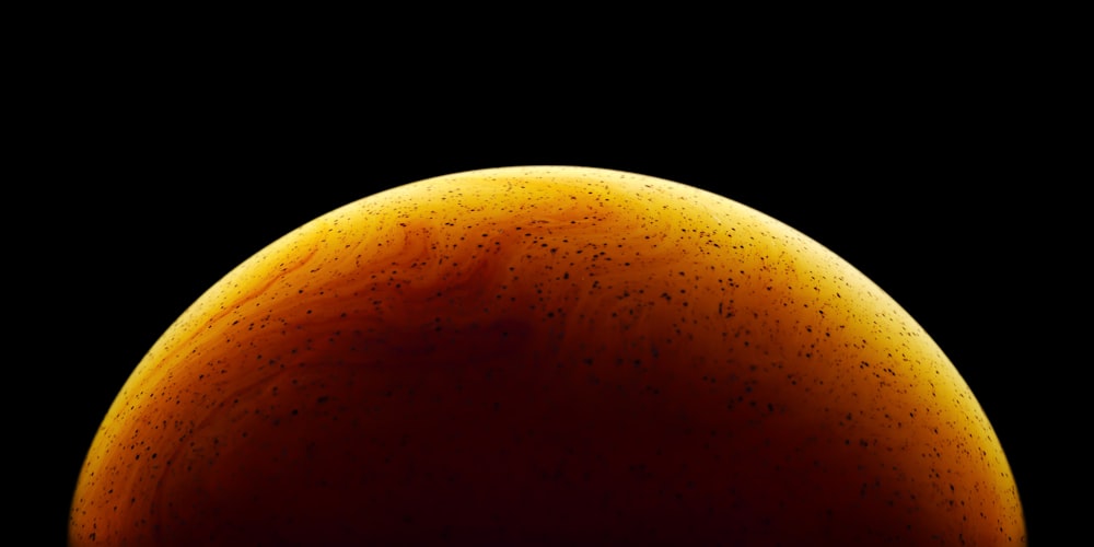 a close up of a yellow object on a black background