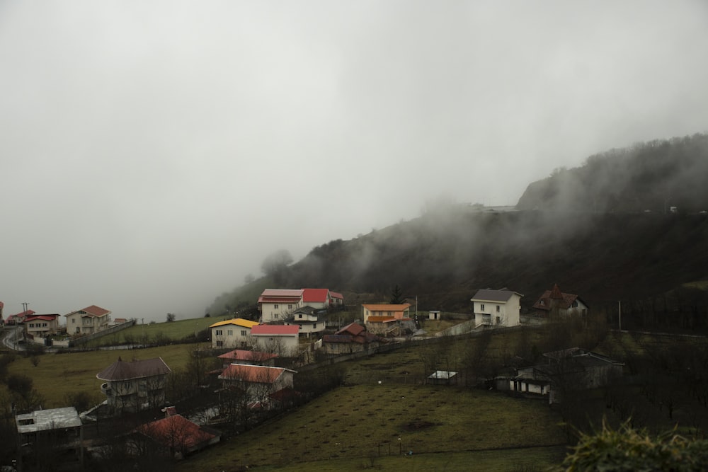 a small village on a hill surrounded by fog