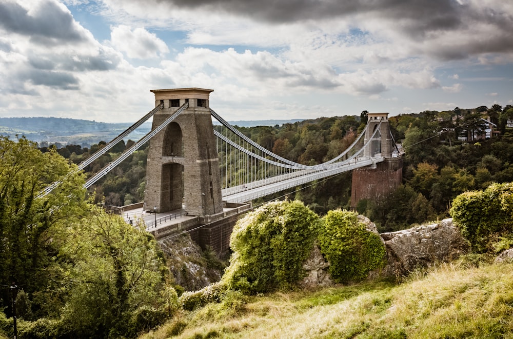 a large suspension bridge over a lush green hillside