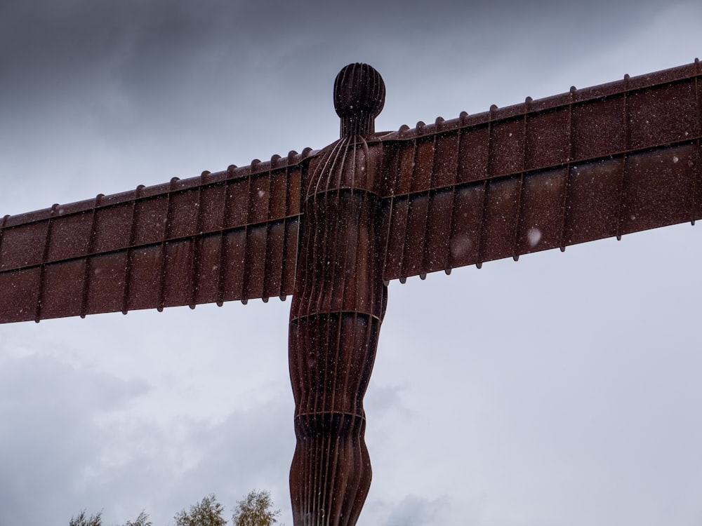 a statue of a man with wings on a cloudy day