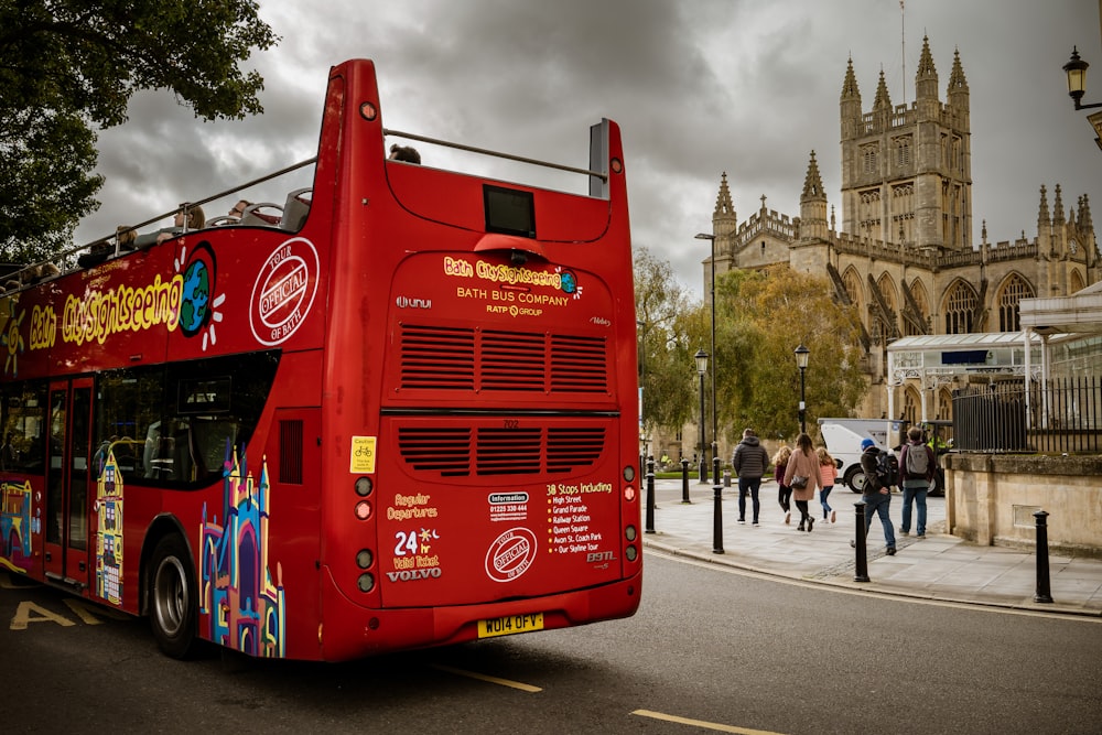 a red double decker bus driving down a street