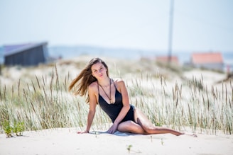 a woman in a bathing suit sitting on the beach
