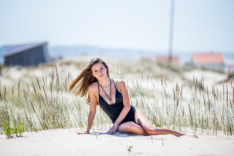 a woman in a bathing suit sitting on the beach